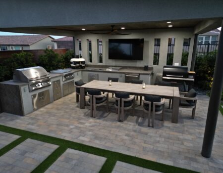A large outdoor kitchen with an entertainment center.