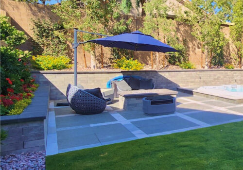 A patio with an umbrella and chairs in it