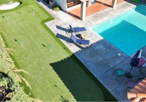 A view of an outdoor pool and lawn from above.