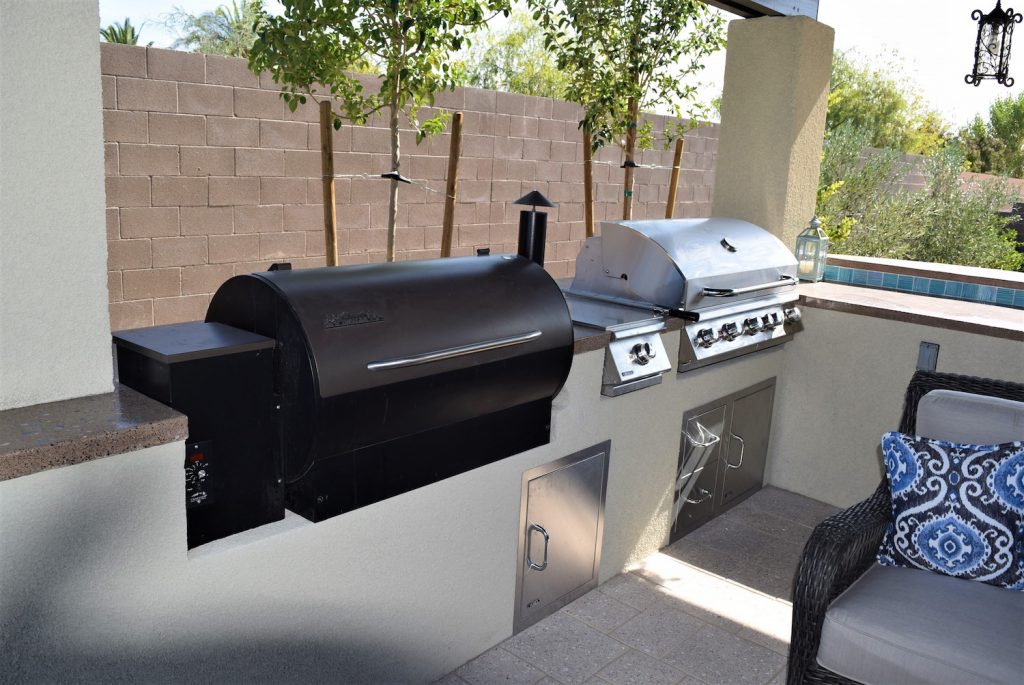 A grill and smoker on the patio of an outdoor kitchen. A grill and smoker on the patio of an outdoor kitchen.