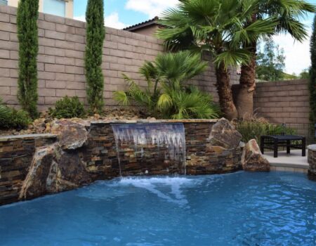 A pool with water falling down the side of it.
